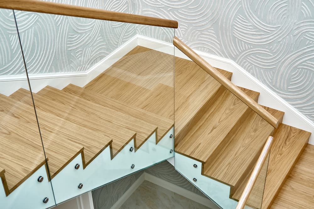 wooden staircase with glass railings